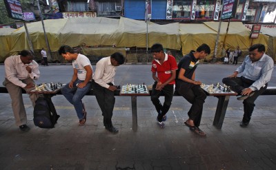 Men play chess at an open air street chess club at Gariahat Boulevard in Kolkata